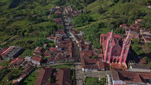 Aerial view of Jerico's colorful colonial town and prominent pink church in lush hills