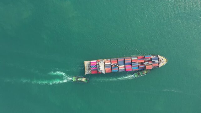 Large container ship navigates open ocean with powerful tugboat escorting it under dramatic dark sky, transporting global containers and showcasing maritime trade logistics for international commerce.