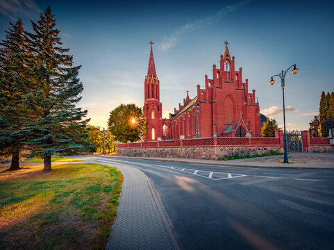 Stunning evening view of red briks St. Matthew Apostle Catholic Church. Majestic summer cityscape of Rokiskis town, Lithuania, Europe. Traveling concept background.