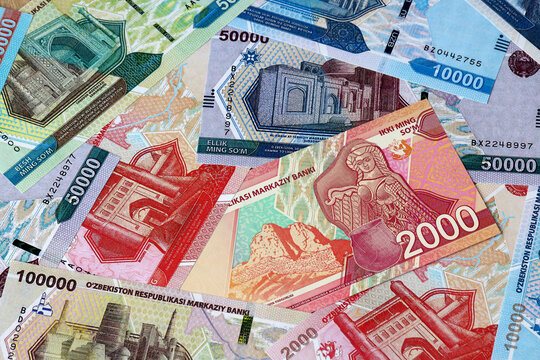 Uzbekistani som money bills in pile on table. Uzbekistan UZS currency cash close up