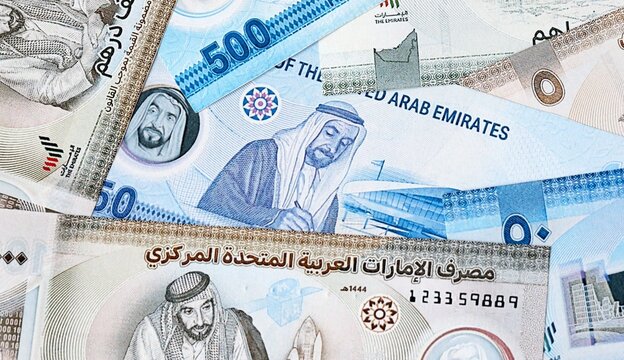 UAE dirham money bills in pile on table. United Arab Emirates AED currency cash close up