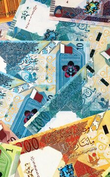 Qatari rial money bills in pile on table. Qatar QAR currency cash close up