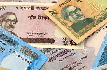 Fototapeta premium Bangladeshi taka money bills in pile on table. Bangladesh BDT currency cash close up