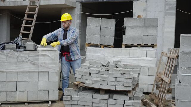 Construction worker moving concrete cinder blocks