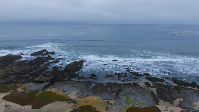 Rocky coastline with waves crashing against dark rocks in ocean