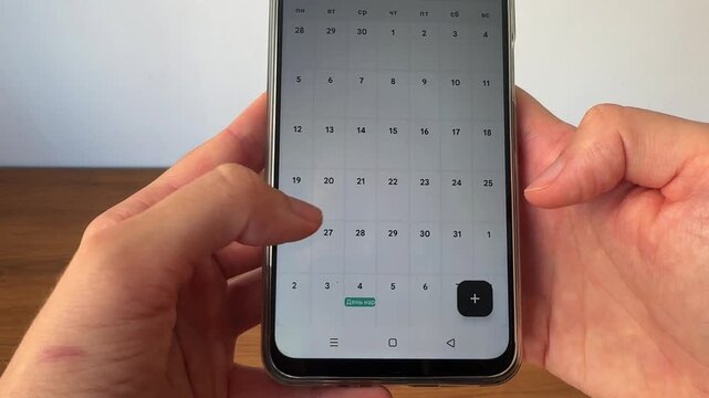 Close-up video of a person viewing a calendar application on a smartphone. Modern productivity concept representing scheduling, time management, planning and organization of daily tasks.