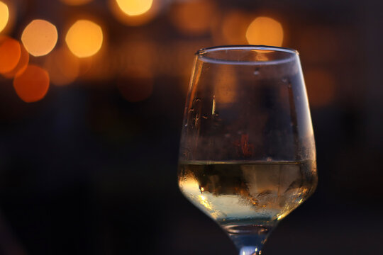 Glass of wine and blurred lights background
