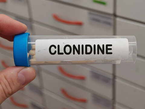Transparent plastic Box of CLONIDINE tablets on a hospital pharmacy table used to treat high blood pressure a centrally acting alpha agonist.