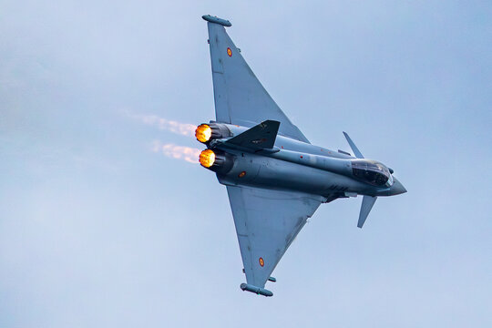 Ein Eurofighter Typhoon der spanischen Luftwaffe zeigt beim Vorfuehrflug einen steilen Steigflug mit zugeschaltetem Nachbrenner. Die beiden Triebwerke erzeugen deutlich sichtbare Flammen.
