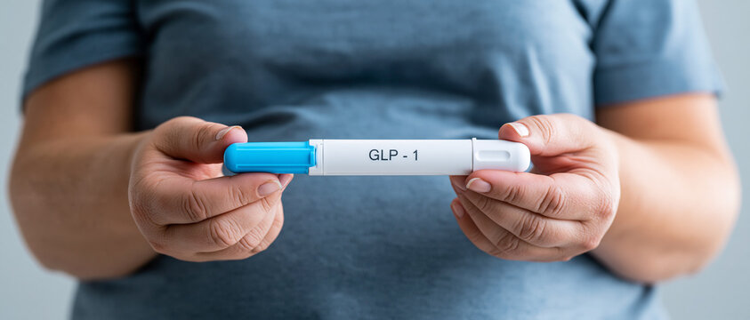 .Mujer con sobrepeso sosteniendo una pluma inyectora de GLP-1. Concepto de tratamiento m&eacute;dico para la p&eacute;rdida de peso y la obesidad.