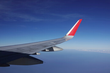 Fototapeta premium A view from the airplane window showing a blue sky; a concept of air transport for tourism.
