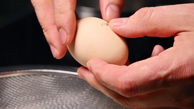 Person shaping dough with hands in a kitchen