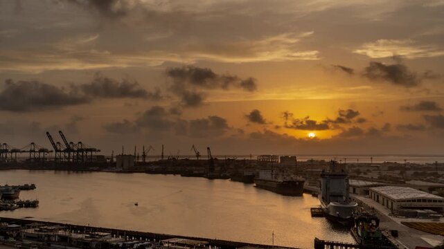 View of KPT Ground Keamari at sunset with industrial cranes and ships docked in the harbour of Karachi, Sindh, Pakistan.