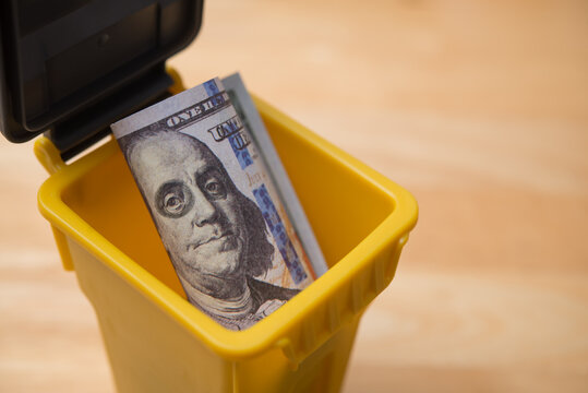 US dollar banknote is disposed in bin. Dedollarisation concept. Countries dumping the US dollar, reduce their reliance on the US dollar as medium of exchange, a reserve currency and unit of account.