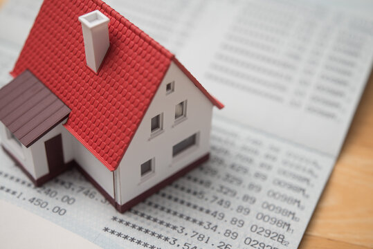 Close up small house on deposit account book bank background. Money management and planning for homebuyer, expense, cost of living, house installment, mortgage loan and so on concept.