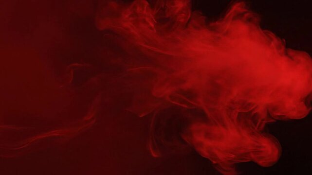 Vibrant red smoke swirls dramatically on a dark background