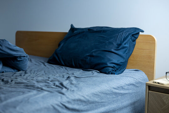 Soft blue bedding rests on a wooden bed frame