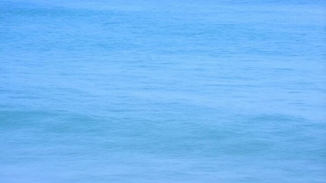 Calm ocean waves gently lapping against the shore. Represents tranquility, relaxation, and the beauty of nature