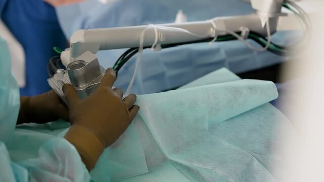 Close up of medical professional using surgical instrument on patient eye under sterile drape. Cool blue tones dominate. Clinical lighting highlights precision. Focus on hands device