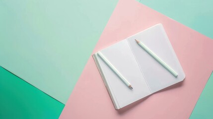 Fototapeta premium Open Notebook with Two White Pens on Colorful Pastel Background for Creative or Office Use