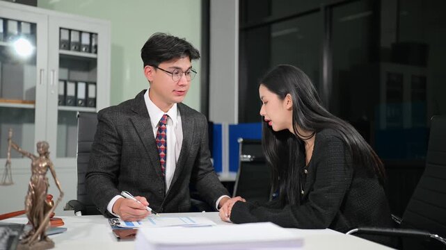 Asian attorney offering support and legal advice to a distressed woman during an office