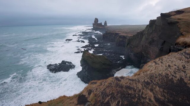View of the rugged basalt cliffs and crashing waves at Snaefellsnes Eyja- og Miklaholtshr, Iceland.