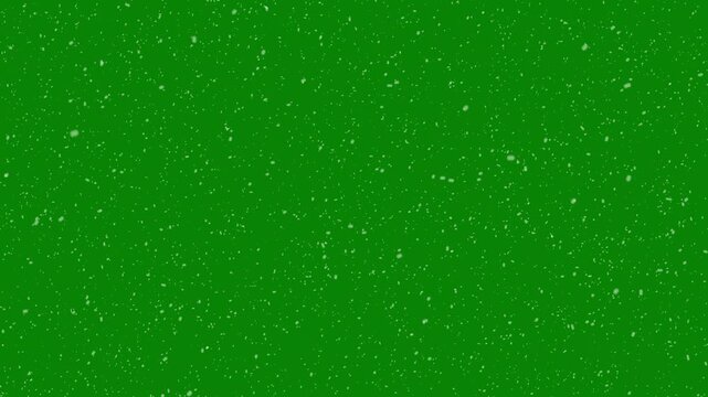 Animated realistic small snowflakes falling densely and slowly through air against on green background. thousands of small snowflakes floating naturally in cold air, 4k video