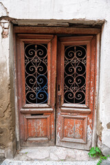 Fototapeta premium Weathered abandoned doorway shows rustic wood with ornate ironwork