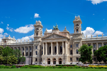 Obraz premium Detailed exterior view of the historic Hungarian Parliament Building in Budapest, Hungary, featuring its iconic dome, ornate facade and Neo-Gothic spires beneath a bright blue sky.