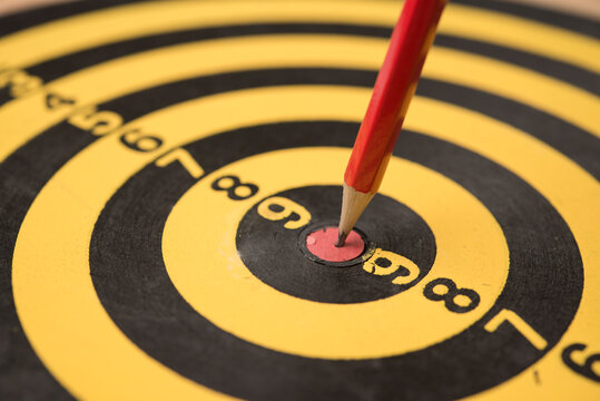 Closeup red pencil hit to the center of dartboard. Success target in the education, graduated from university, high score or pass the examination, get a scholarship, get the good job and so on concept