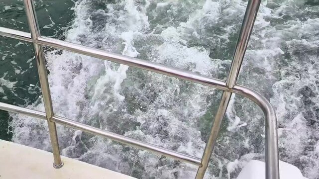 boat motor creates churning wake in waterway. powerful boat motor propeller churns water during river cruise. modern boat wake demonstrates water transport movement.
