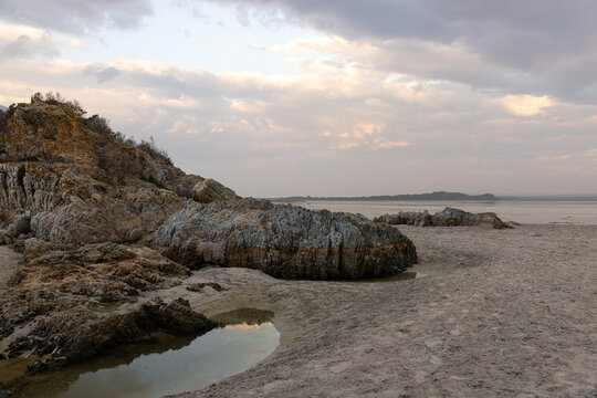 low tide at rocky coastline of Grotto Beach, Hermanus, South Africa at dusk