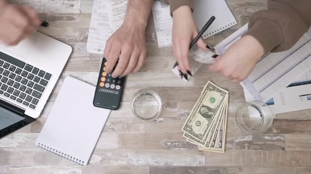 Collaborative team calculating monthly expenses and managing budget at office desk finance calculator money accounting business