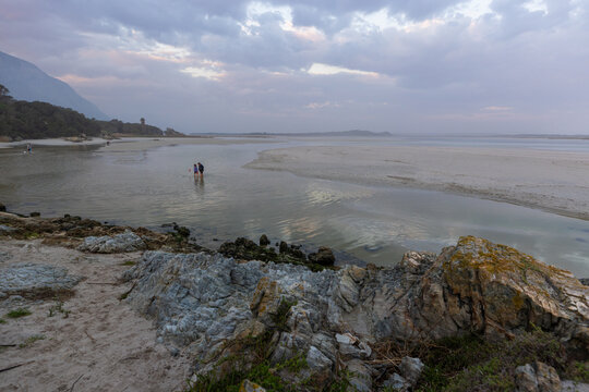 low tide at rocky coastline of Grotto Beach, Hermanus, South Africa at dusk
