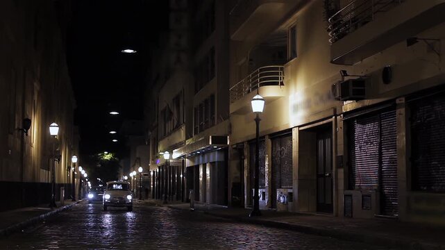 Classic Retro Automobile Moving Down Historic City Alley with Streetlights in San Telmo Buenos Aires - 4K