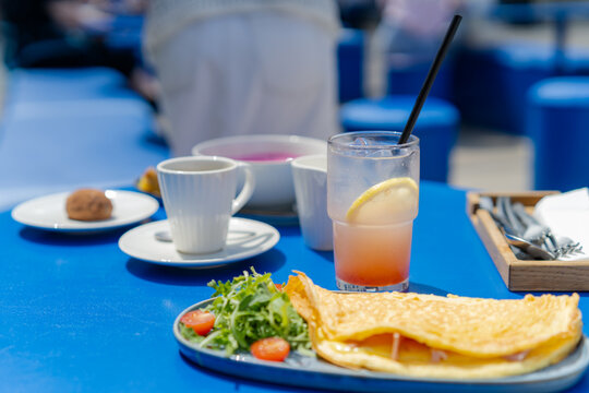 Horizontal view of breakfast table with refreshing grapefruit lemonade at a summer cafe terrace