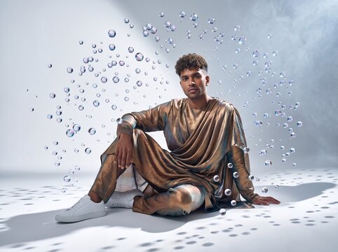 Man Sitting Contemplatively Among Floating Bubbles