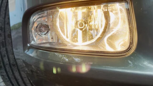 An active vehicle engine idles smoothly on the road. The bright headlight shines directly forward, creating a steady mechanical rumbling sound that fills the surrounding air.