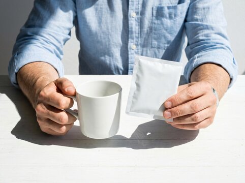 Person holding coffee cup and sachet packet