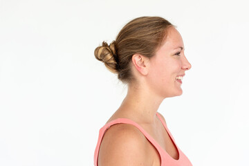 Obraz premium Profile of a smiling woman with a bun, wearing a pink top.