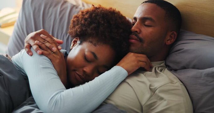 Couple, cuddle and holding hands on bed, home and bonding with partner in bedroom, support and love. Black people, sleeping and resting with spouse in house, affection and commitment for relationship