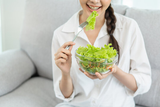 Healthy lifestyle concept with young woman eating organic salad.