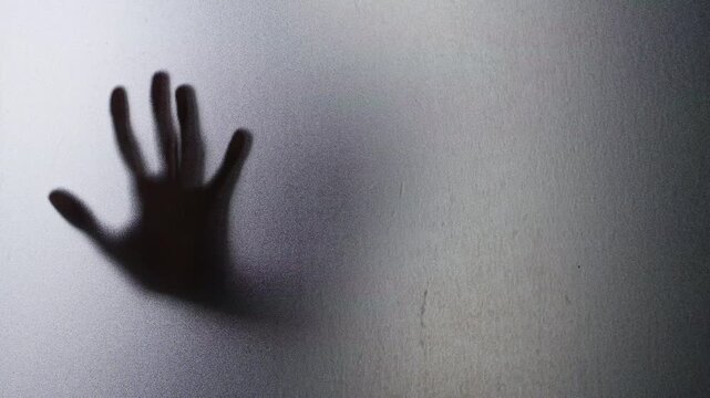Blurred Human Hand Pressed Against Frosted Glass on a Grainy Translucent Surface. Fear, Isolation, Vulnerability and Psychological Distress
