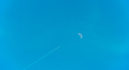 Airplane flying along the moon in a blue sky, Almere, Flevoland, The Netherlands, June 22, 2026 © Naj