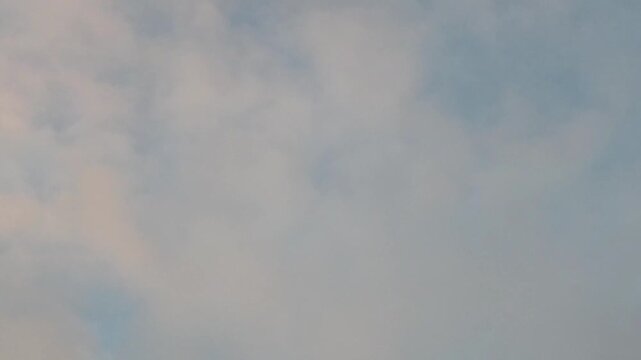 Pink clouds moving in the sky at dawn
