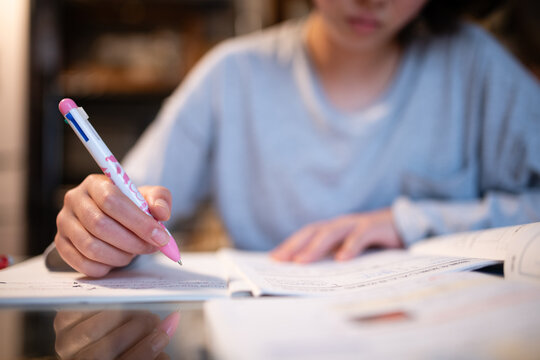 室内で集中してノートにペンで文字を書く中学生の手元 - 勉強・学習