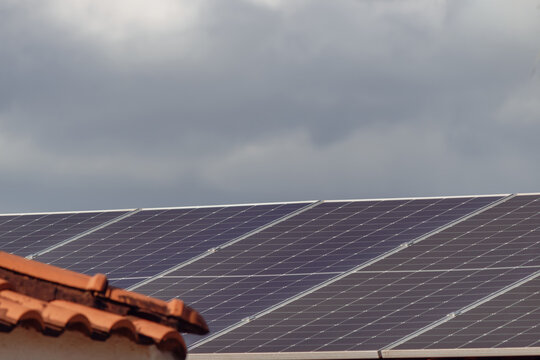 Close-Up of Rooftop Solar Panels on House Under Cloudy Sky