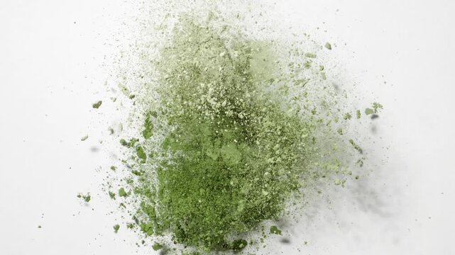 Top view slow-motion capture of three pale green powder accumulations disrupted from beneath, causing a burst on a light grey backdrop