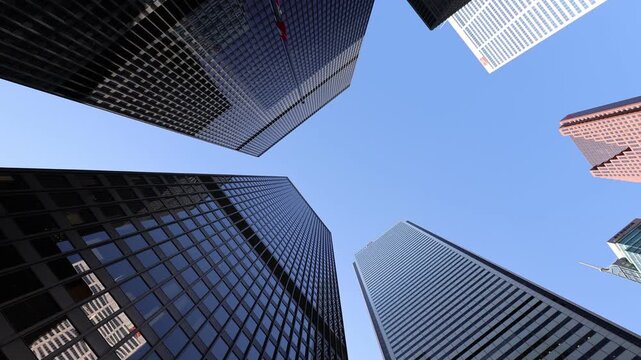 Toronto, Ontario, Canada - 19 June 2026: View of the Toronto Financial District with modern glass skyscrapers reaching into a clear blue sky.