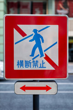 Japanese No Jaywalking Traffic Sign with Directional Arrow Panel on Pole